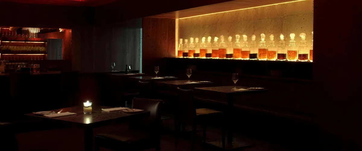 Ciemna sala restauracji z podświetloną półką słojów z kiszonkami